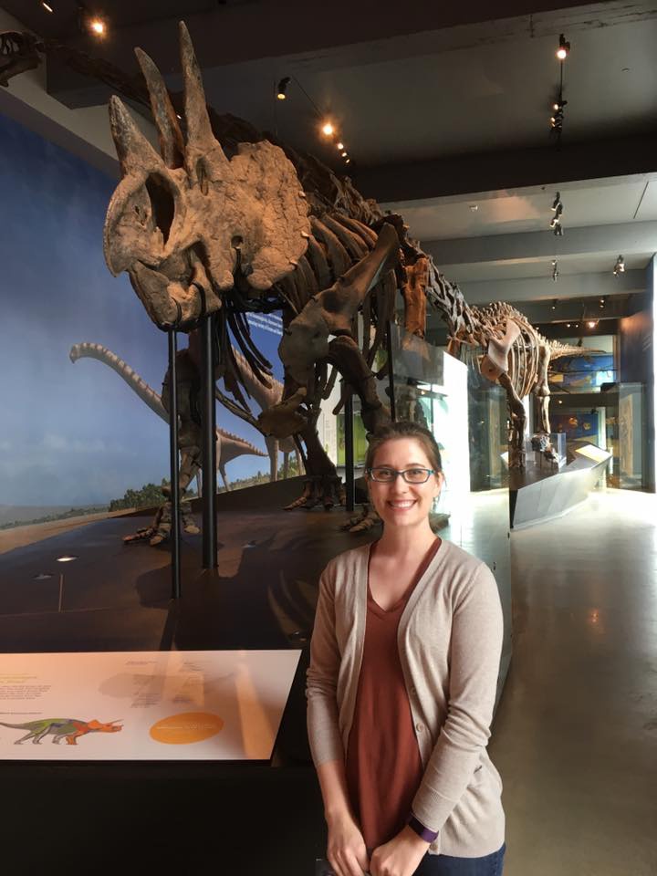 Jenna standing in front of triceritops skeleton.